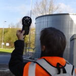 An odour panellist measures wind direction as part of a sniff survey